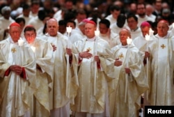 Cardinals hold candles during the Easter vigil Mass led by Pope Francis in Saint Peter's Basilica at the Vatican, March 31, 2018.