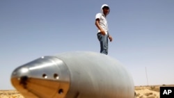 September 1: An anti-Gaddafi fighter stands on an SA-5 SAM missile in Burkan air defense military base, which was destroyed by a NATO air strike. REUTERS/Goran Tomasevic