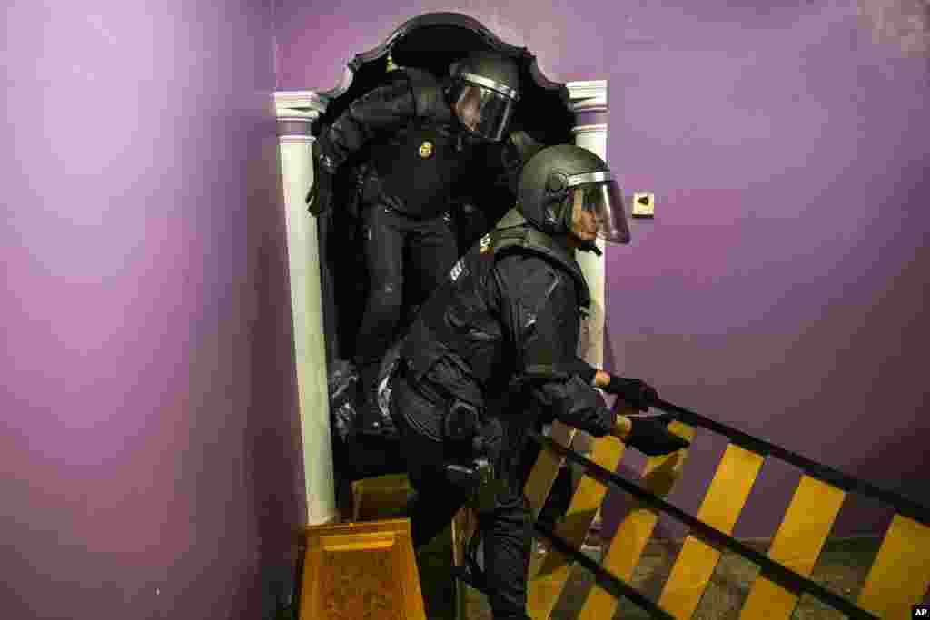 Police enter the apartment of Emilia Montoya Vazquez by forcing their way in between furniture after they broke down the main door to evict her and her family in Madrid, Spain. Montoya, who lived with her son and daughter in law, both unemployed, and three grandchildren of 7, 6, 3 years old, had accumulated a debt with the (EMV) City Hall Housing Company as she could not afford to pay the rent due to her only income - a state benefit of 460 euros ($522) a month.