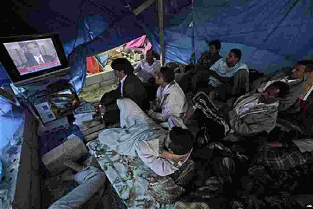 Anti-government protesters watch a television broadcasting President Barack Obama's statement on the death of al-Qaida leader Osama bin Laden in a tent at the site of a demonstration demanding the resignation of Yemeni President Ali Abdullah Saleh, in San