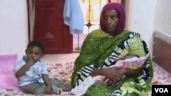 ນາງ Meriam Ibrahim ນັ່່ງຢູ່ຂ້າງລູກຊາຍ ທ້າວ Martin ອາຍຸ 20 ເດືອນ ແລະອູ້ມລູກສາວທີ່ເກີດໃໝ່ຢູ່ໃນຄຸກ