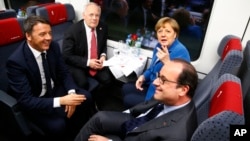 Italian Prime Minister Matteo Renzi (clockwise from left), Swiss Federal President Johann Schneider-Ammann, (second left), German Chancellor Angela Merkel (back right), and French President Francois Hollande sit in the VIP-train on the opening day of the Gotthard rail tunnel, Switzerland, Wednesday, June 1, 2016. The construction of the 57 kilometer long tunnel began in 1999, the breakthrough was in 2010. Commercial operation will begin December 2016. (Ruben Sprich/Pool Photo via AP)