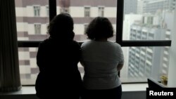 FILE - Sisters from Saudi Arabia, who go by aliases Reem and Rawan, are pictured at an office in Hong Kong, China, Feb. 23, 2019.