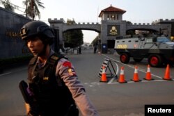 FILE - A mobile brigade policeman stands in front of the Mobile Police Brigade (Brimob) headquarters in Depok, south of Jakarta, Indonesia, May 9, 2018.