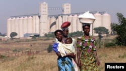 Malawian women walk past empty grain silos in the capital Lilongwe, (File photo).