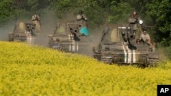 FILE - Ukrainian self-propelled artillery vehicles make their way to positions near Donetsk, eastern Ukraine, June 7, 2015. A new report says some Ukrainian artillery united were tracked by Russian hackers from late 2014 through 2016.