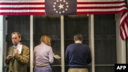 People prepare to cast their ballots inside a polling station just after midnight on November 6, 2012 in Dixville Notch, New Hampshire, the very first voting to take place in the 2012 US presidential election. 