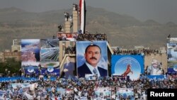 FILE - Supporters of Yemen's former President Ali Abdullah Saleh climb pillars of the Unknown Soldier Monument during a rally to mark the 35th anniversary of the establishment of the General People's Congress party, led by Saleh, Sanaa, Aug. 24, 2017. 