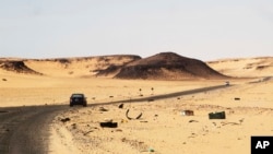 FILE - A car driving along the bandit-plagued road between Sebha and Ubari in southwestern Libya, Dec. 24, 2013. 