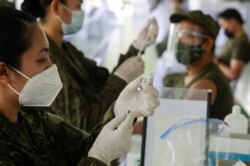 Para dokter TNI AD bersiap menyuntikkan vaksin Sinovac saat dimulainya vaksinasi di Fort Bonifacio, Metro Manila, Filipina pada Selasa, 2 Maret 2021. (Foto: AP)