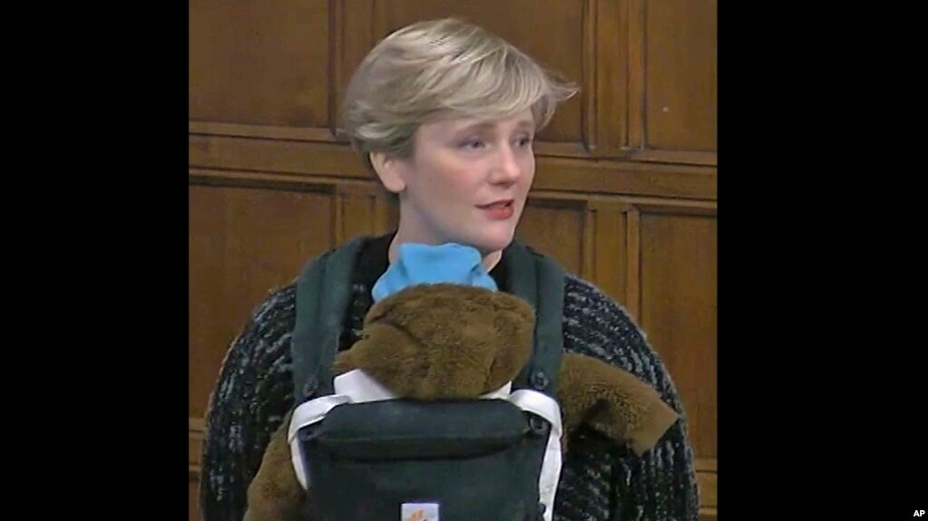 In this video capture taken from House of Commons TV, Labour MP Stella Creasy carries her son, Pip, during a Westminster Hall debate in Parliment, London, Tuesday, Nov. 23, 2021. (House of Commons/PA via AP)