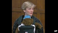 In this video capture taken from House of Commons TV, Labour MP Stella Creasy carries her son, Pip, during a Westminster Hall debate in Parliment, London, Tuesday, Nov. 23, 2021. (House of Commons/PA via AP)