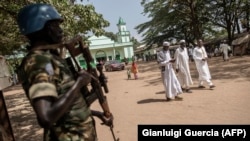 FILE - A Burundian member of the peacekeeping force from the U.N. Multidimensional Integrated Stabilization Mission in the Central African Republic (MINUSCA) stands guard as Muslims leave the Grand Mosque in the PK5 neighborhood of Bangui, Nov. 27, 2015.