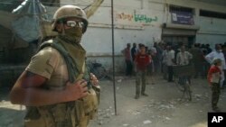 A Russian soldier guards the area at a city market in Deir el-Zour, Syria, Sept. 15, 2017. A U.S.-backed force in Syria said a Russian airstrike wounded six of its fighters Saturday near Deir el-Zour city. 