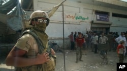 A Russian soldier guards the area at a city market in Deir el-Zour, Syria, Sept. 15, 2017. A U.S.-backed force in Syria said a Russian airstrike wounded six of its fighters Saturday near Deir el-Zour city. 