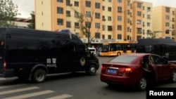 ລົດຕຳຫຼວດ ໜ່ວຍ SWAT ຂອງຈີນ ກຳລັງແລ່ນ ຢູ່ຕາມຖະໜົນຫົນທາງ ໃນເມືອງ Urumqi ຫຼັງຈາກ ເກີດເຫດລະເບີດ (22 ພຶດສະພາ 2014)