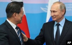 Russian President Vladimir Putin, left, and his South Korean counterpart Moon Jae-in smile chating after signing ceremony at the Eastern Economic Forum in Vladivostok, Russia, on Wednesday, Sept. 6, 2017.