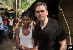 American actor Matt Dillon, right, shakes hands with Noor Alam, a 17-year old Rohingya survivor of human-trafficking at Thetkabyin village, north of Sittwe in the western state of Rakhine, Myanmar, May 29, 2015.