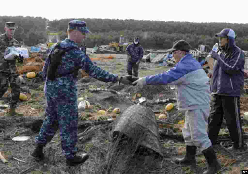 In a March 14, 2011 photo provided by the Navy Visual News Service, Mineman 2nd Class Cody Stone of Phoenix, Az., assigned to Naval Air Facility Misawa (NAFM), recovers a spool of fisherman netting and returns it to a local civilian during a volunteer cle