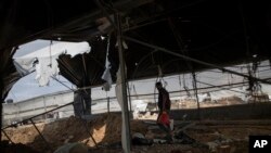 Seorang pria Palestina memeriksa kerusakan sebuah peternakan unggas, menyusul serangan udara Israel dini hari di kota Rafah, Jalur Gaza selatan, Minggu, 12 September 2021. (AP Photo/Khalil Hamra)
