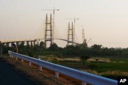 FILE - Work continues on Cambodia longest bridge before it is inauguration in Neak Loeung, southeast of Phnom Penh, Cambodia, Jan. 14, 2015.