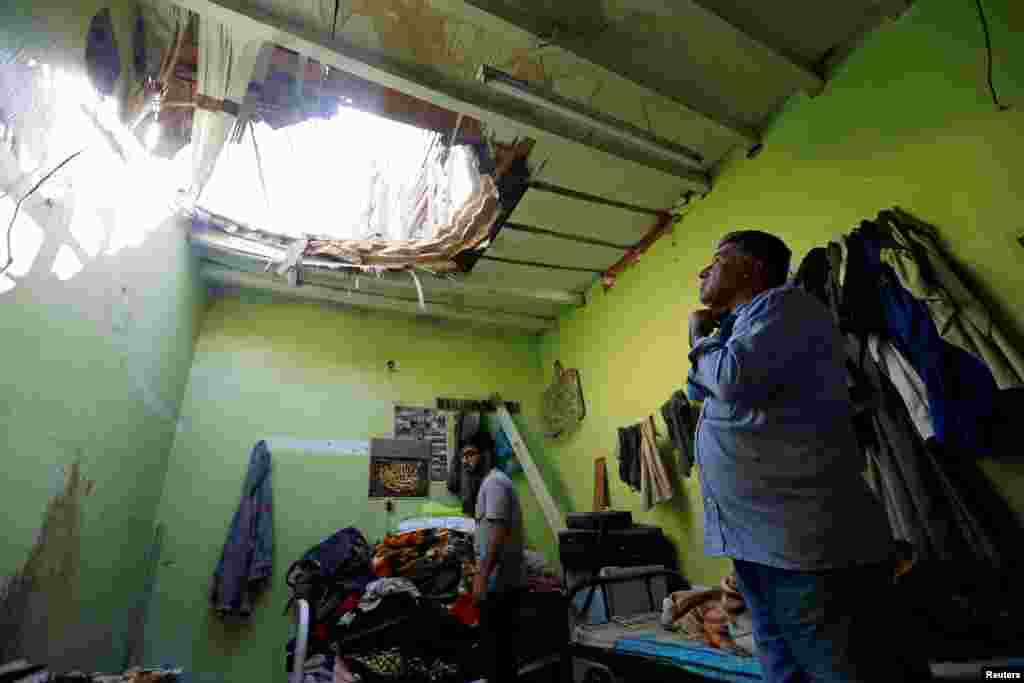 People check the damage after debris from ballistic missiles fired by Yemen's Houthi militia fell onto a house in Riyadh, Saudi Arabia.