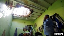 People check the damage after debris from ballistic missiles fired by Yemen's Houthi militia fell onto a house in Riyadh, Saudi Arabia.