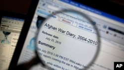 This photograph shows a magnifying glass held in front of a computer screen, displaying an Afghan War Diary on the Wikileaks website, 26 July 2010