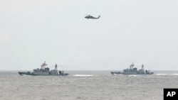 FILE - A Taiwan Navy helicopter flies over two Taiwan made corvettes during a navy exercise in the bound of Suao naval station in Yilan County, northeast of Taiwan, Apr. 13, 2018. 