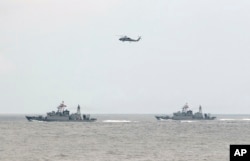 FILE - A Taiwan Navy helicopter flies over two Taiwan made corvettes during a navy exercise in the bound of Suao naval station in Yilan County, northeast of Taiwan, Apr. 13, 2018.