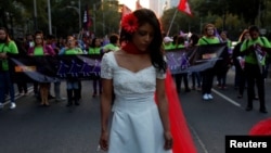 FILE - A woman takes part in a demonstration to commemorate the U.N. International Day for the Elimination of Violence against Women in Mexico City, Nov. 25, 2016.