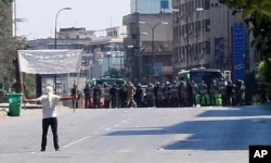 Un manifestant fait face à la police anti-émeute à Khalidia, près de Homs (4 novembre 2011)