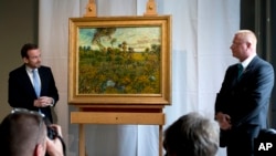 Giám đốc Viện Bảo tàng Van Gogh Axel Ruger (trái) và nhân viên bảo vệ bên cạnh bức tranh vừa đước phát hiện "Hoàng hôn ở Montmajour" của Van Gogh, ngày 9/9/2013.