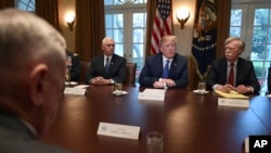 FILE - U.S. President Donald Trump, second from right, speaks in the Cabinet Room of the White House in Washington, April 9, 2018, at the start of a meeting with military and national security leaders. 