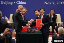 Business leaders shake hands during signing ceremony attended by U.S. President Donald Trump and China's President Xi Jinping at the Great Hall of the People in Beijing, Nov. 9, 2017.