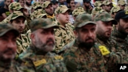 FILE - Hezbollah fighters listen to Hezbollah leader Sheik Hassan Nasrallah, as he speaks via video link during a rally to mark the Hezbollah martyr day, in the southern suburb of Beirut, Lebanon, Beirut, Lebanon, Wednesday, Nov. 11, 2015. 