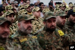 FILE - Hezbollah fighters listen to Hezbollah leader Sheik Hassan Nasrallah, as he speaks via a video link during a rally to mark the Hezbollah martyr day, in Beirut, Lebanon, Nov. 11, 2015.