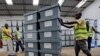 Election workers move boxes of voting materials at the National Electoral Commission headquarters in Monrovia, Oct. 9, 2017.