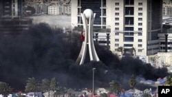 Black smoke billows from burning tents in Pearl Square in Bahraini capital Manama on March 16, 2011