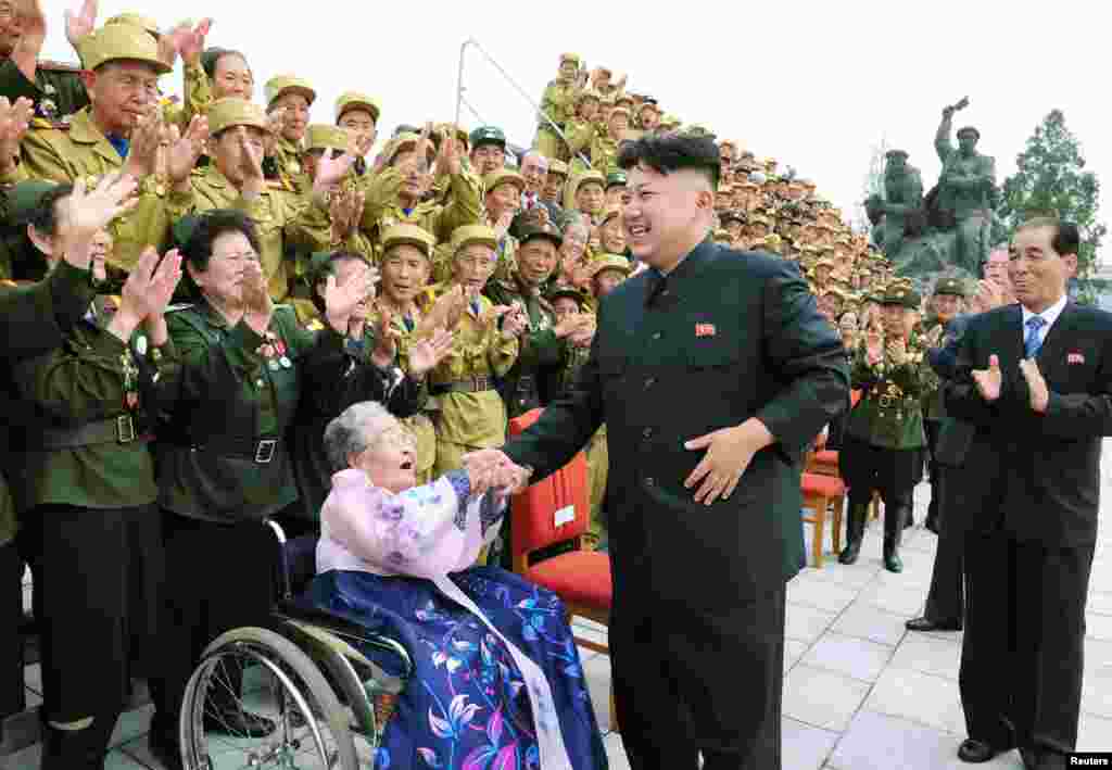 Lãnh tụ Bắc Triều Tiên Kim Jong-Un tươi cười chụp ảnh cùng các đại biểu cựu chiến binh ở Bình Nhưỡng tham gia lễ kỷ niệm 60 năm ngày ký kết thỏa thuận chấm dứt chiến tranh Triều Tiên. (Ảnh do thông tấn xã trung ương Bắc Triều Tiên công bố)