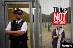 A demonstrator protests next to the specially erected fence surrounding the U.S. ambassador's residence, Winfield House, where U.S. President Donald Trump and the first lady Melania Trump are staying, in London, July 12, 2018.