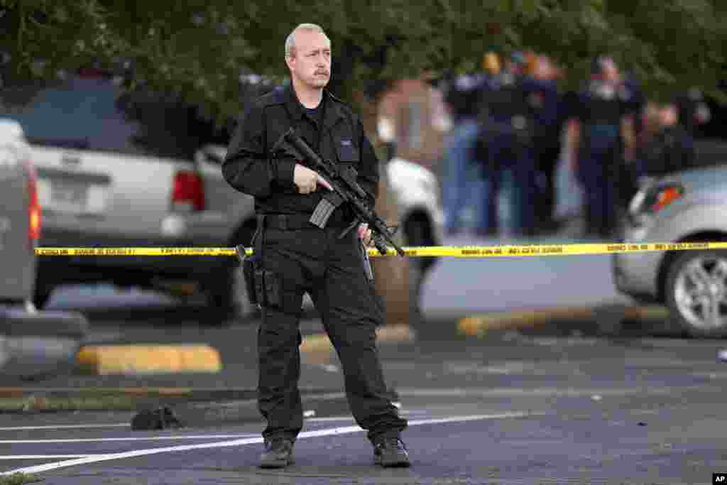 A SWAT team officer stands watch near an apartment house where the suspect in a shooting at a movie theatre lived in Aurora, Colorado, July 20, 2012.