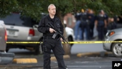 一名特警隊員星期五在科羅拉多州的奧羅拉槍殺嫌疑人住所外守衛
