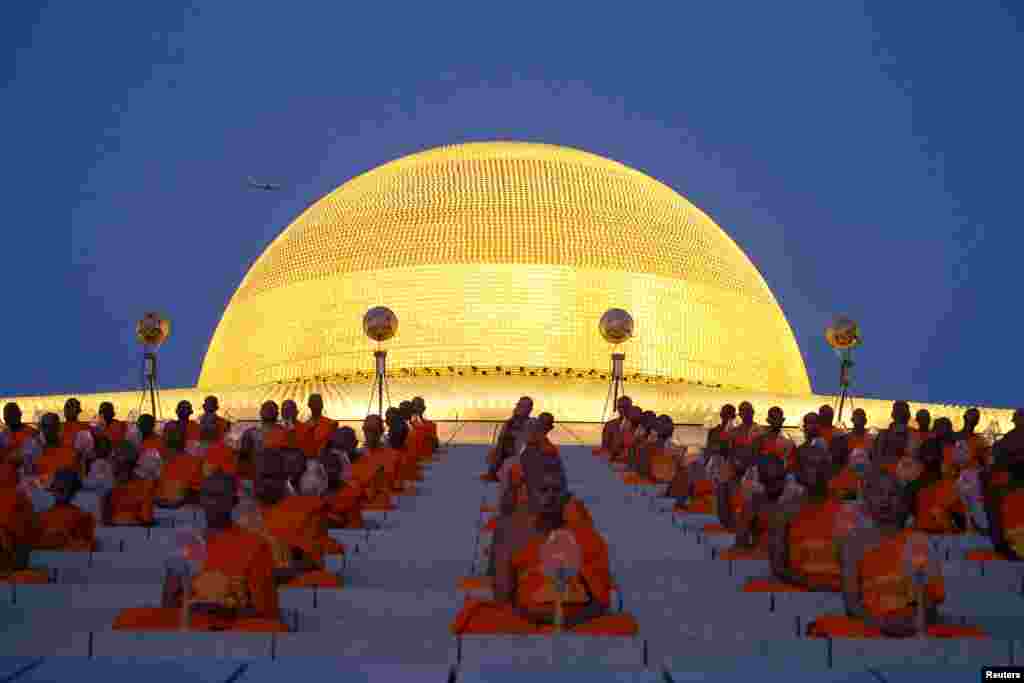 Buddhist monks pray at the Wat Phra Dhammakaya temple during a ceremony to commemorate Makha Bucha Day outside Bangkok, Thailand.