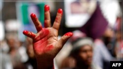Một người biểu tình giơ bàn tay sơn đỏ, biểu hiện tình trạng đổ máu, trong một cuộc biểu tình ở thành phố Taiz đòi Tổng thống Yemen từ chức