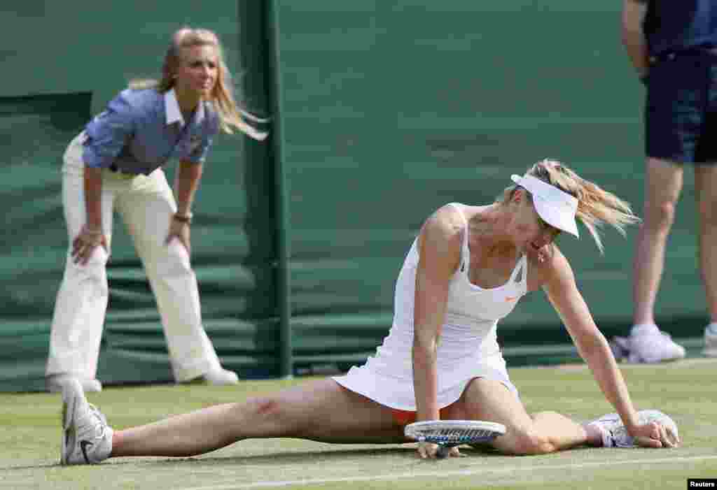 Maria Sharapova of Russia slips during her women&#39;s singles tennis match against Michelle Larcher De Brito of Portugal at the Wimbledon Tennis Championships, in London. 