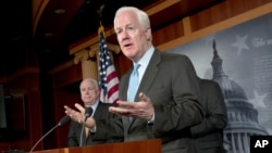  Sen. John Cornyn, R-Texas, right, accompanied by Sen. John McCain, R-Ariz., gestures during a news conference on Capitol Hill in Washington, Tuesday, June 26, 2012