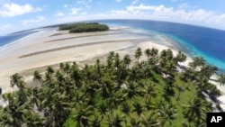 FILE - This Nov. 6, 2015, photo shows a large section of land between the trees washed away due to continuing rising sea leaves on Majuro Atoll, Marshall. 