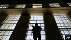 A guard stands watch over the east block of death row at San Quentin State Prison, Aug. 16, 2016, in San Quentin, Calif.