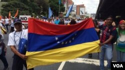 Manifestantes con la bandera de Venezuela piden cambios radicales en el gobierno de su país. 1 de abril de 2017. Foto: Álvaro Algarra / VOA.